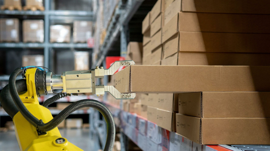 Mobile robots perform packaging and labeling and pallet shuttle tasks in a dark warehouse.