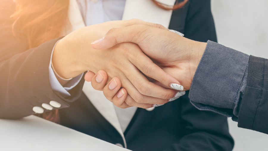 An enVista consultant shakes hands with an enVista partner.