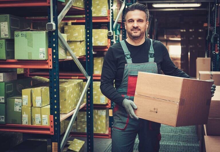 A man holding a box in a warehouse