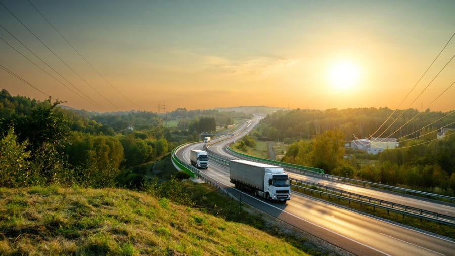 White,Trucks,Driving,On,The,Highway,Winding,Through,Forested,Landscape