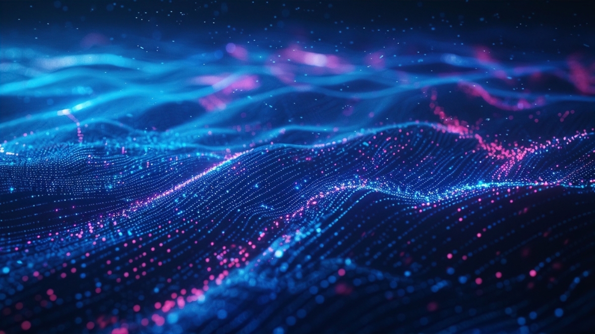 A digital abstract image showing glowing blue and pink dots forming wave-like patterns, resembling a futuristic cloud computing landscape or data visualization, set against a dark background.