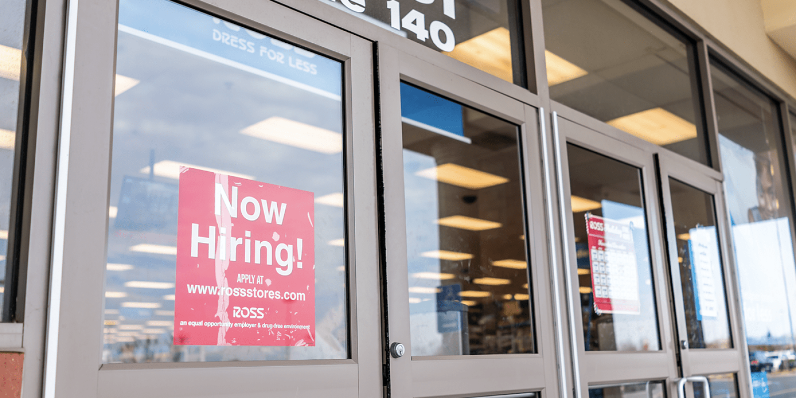 now hiring sign on retail door