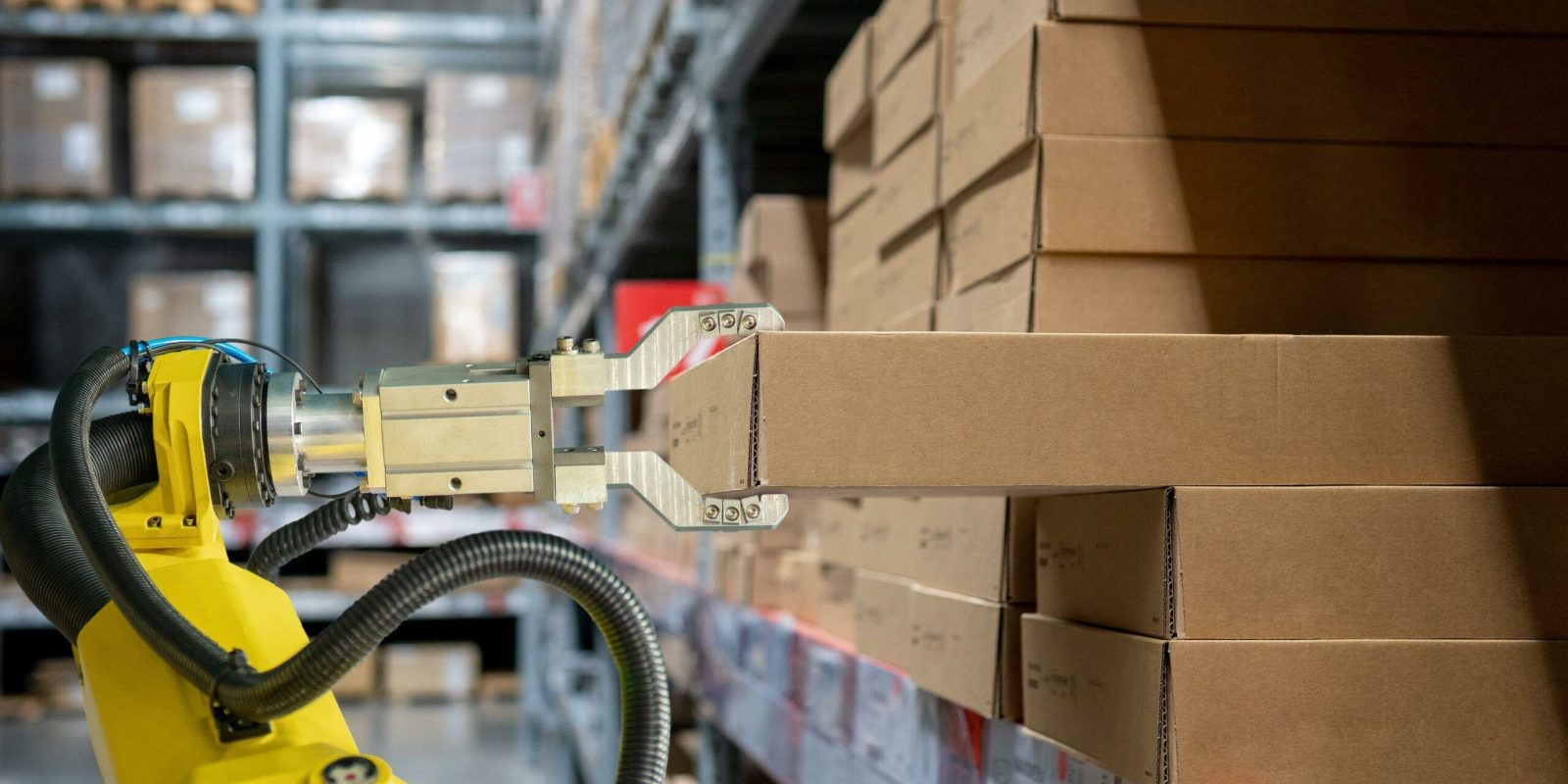 Mobile robots perform packaging and labeling and pallet shuttle tasks in a dark warehouse.