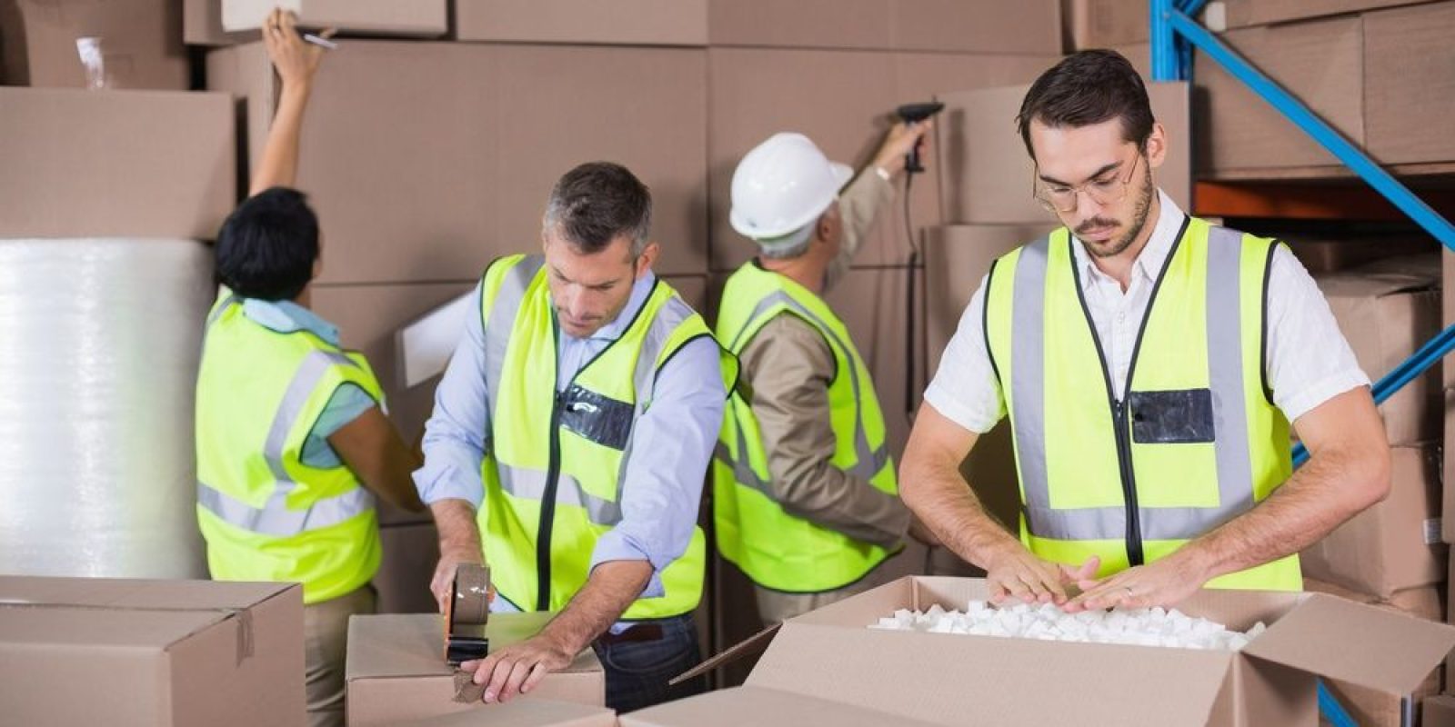 Warehouse workers in yellow vests preparing a shipment