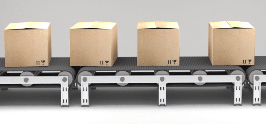 Capture2 Four closed cardboard boxes are placed in a row on a conveyor belt, each box showing standard handling symbols. The background is plain and light-colored.