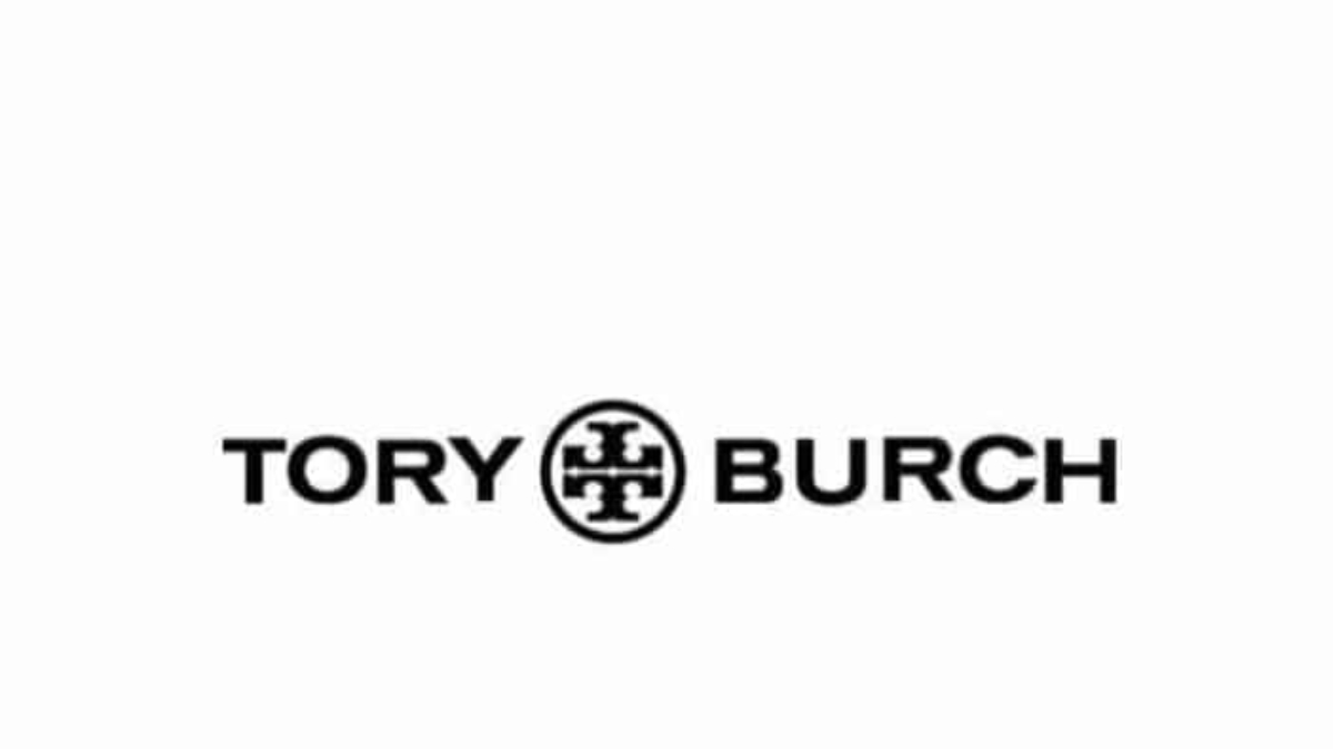 The image displays the Tory Burch logo with the brand name Tory Burch in bold black letters, separated by a circular geometric emblem in the center on a white background.