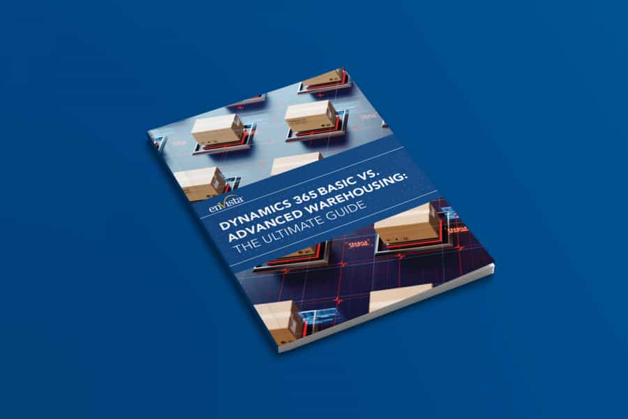 A book titled Dynamics 365 Basic vs. Advanced Warehousing: The Ultimate Guide lies on a blue surface, featuring images of shipping boxes and warehouse graphics on its cover.