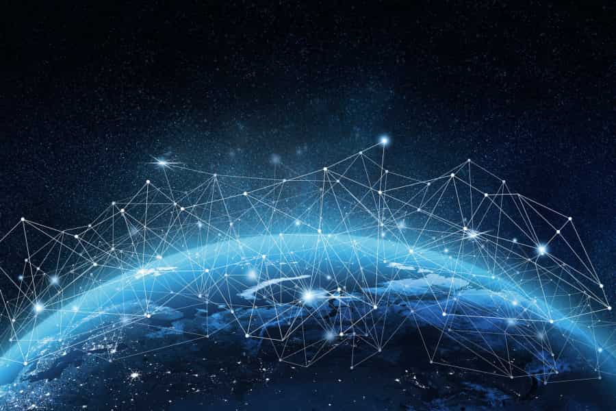 View of Earth from space with a network of glowing lines and points connecting across the surface, symbolizing global digital connectivity and data exchange on a dark, starry background.
