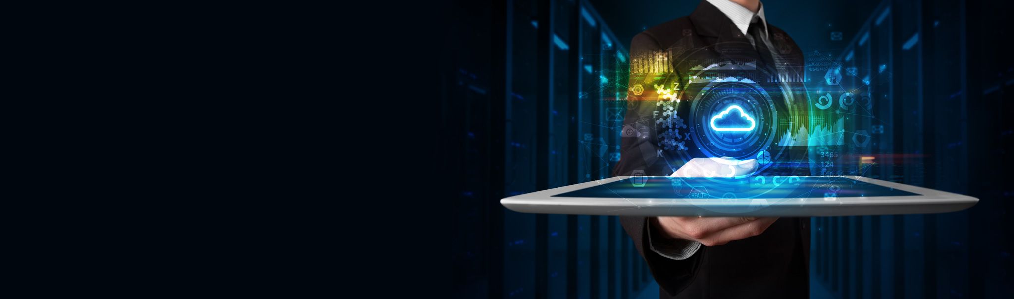 A person in a suit holding a tablet with a glowing cloud computing icon and digital data graphics hovering above it, symbolizing cloud technology and data management, with a dark server room background.