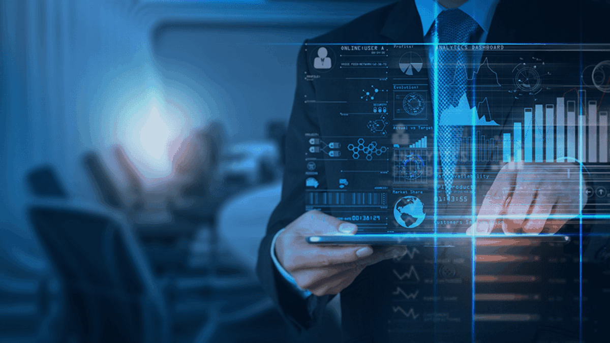 A man in a suit uses a tablet device, with futuristic digital data graphics and charts projected in front of him—highlighting the impact of Power BI consulting services. In the background, a blurred office setting with empty chairs is visible.