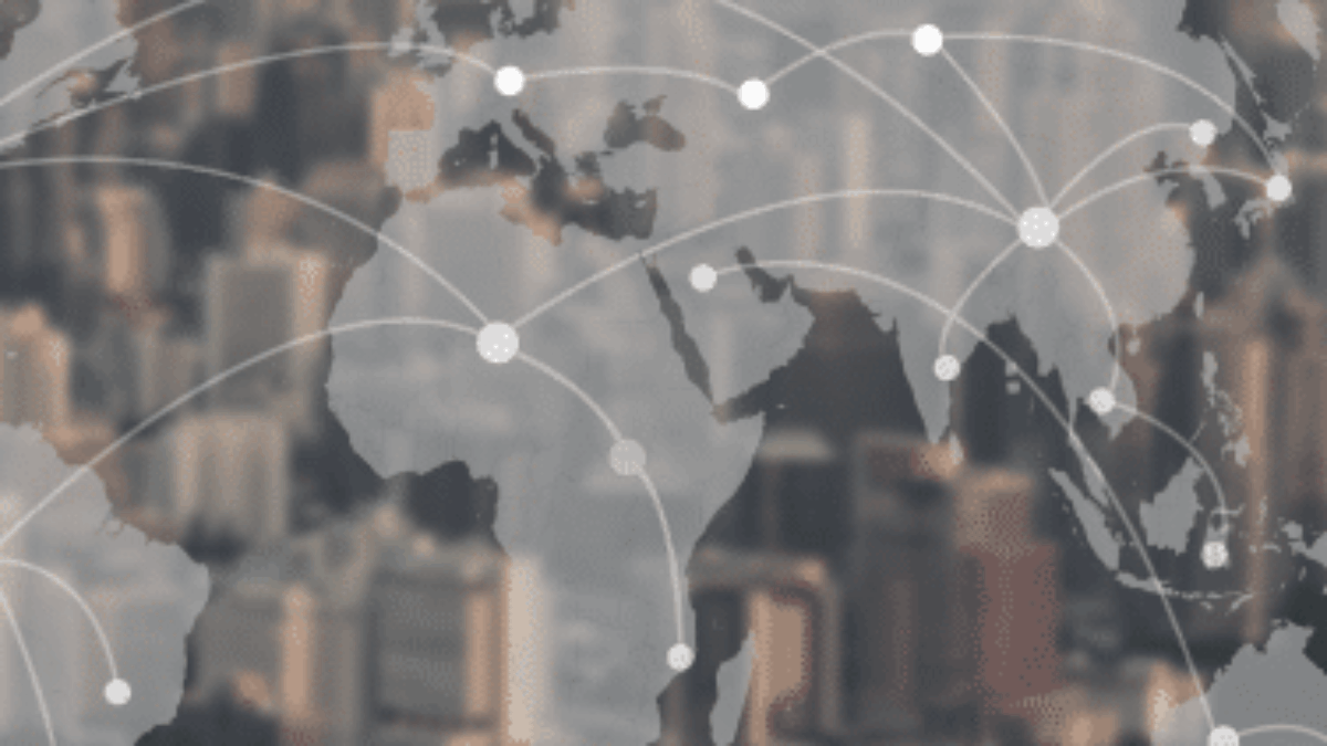 A world map with connected nodes is overlaid on a blurred cityscape, symbolizing global communication and networking. White lines link multiple points across continents.