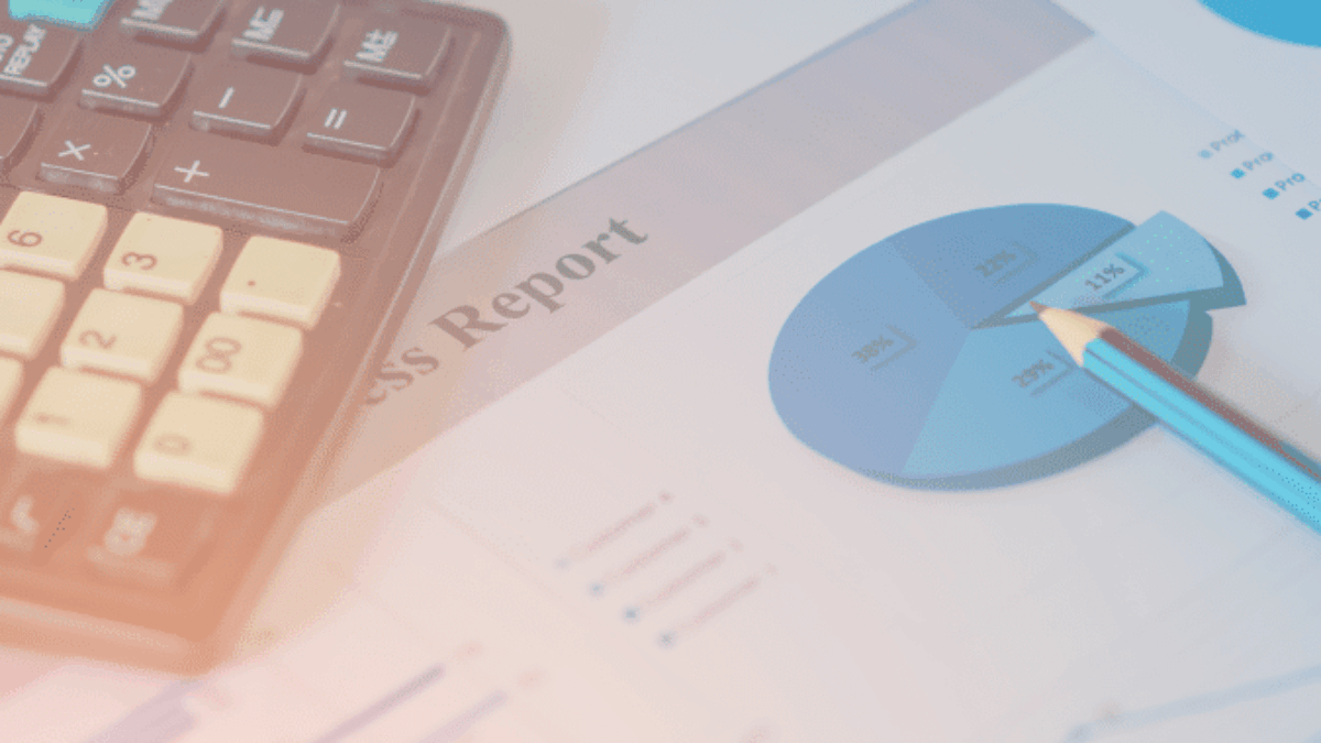 A calculator and a pencil rest on printed business reports featuring pie charts and graphs with financial data.