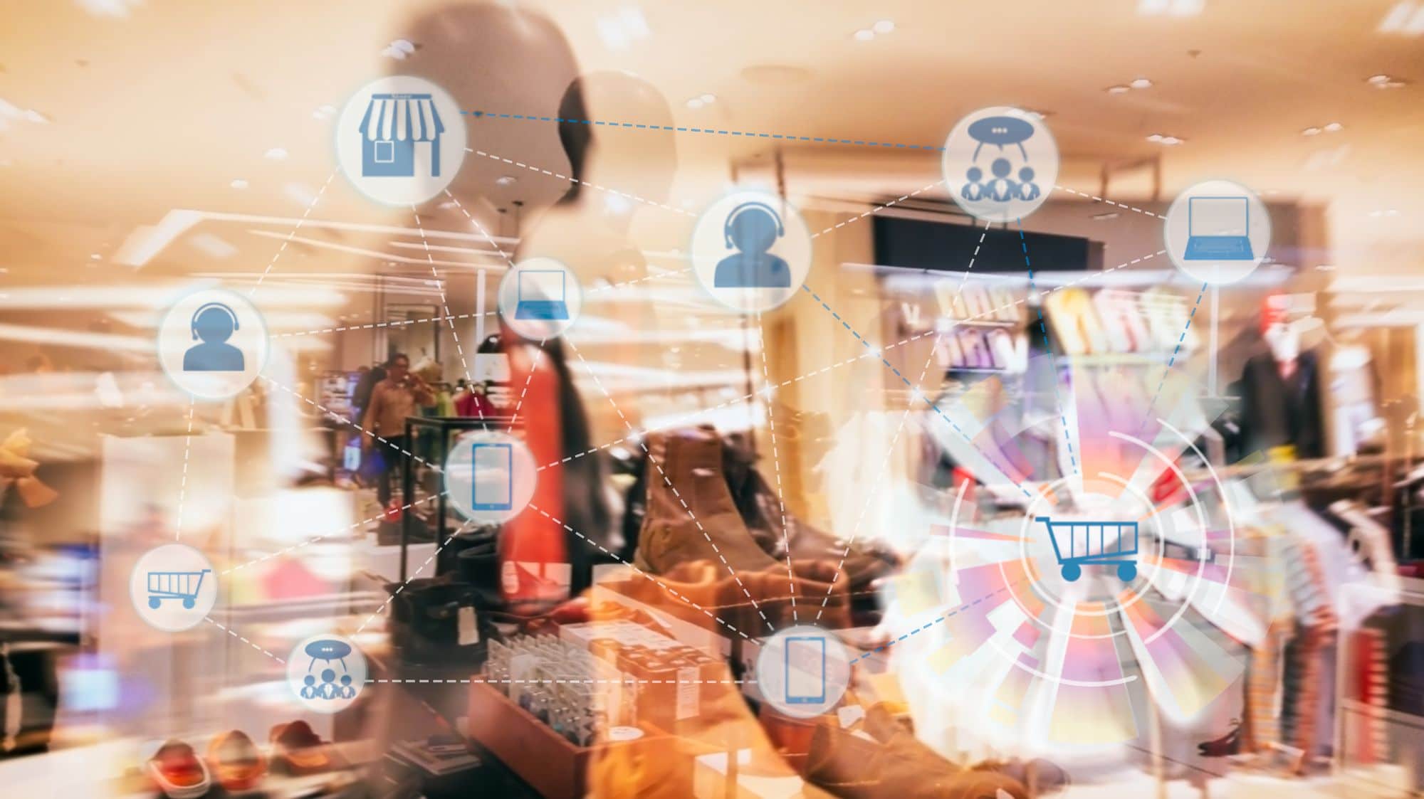 shutterstock_525896389_optimized A blurred image of a retail clothing store interior with digital icons overlaid, showing connected symbols for shopping, customers, mobile devices, and online platforms, representing omnichannel retail and modern commerce.