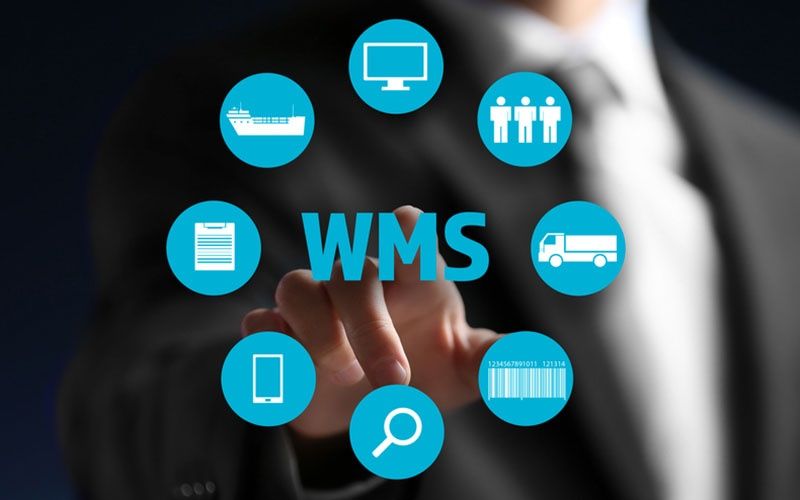 wms image blog cropped A person in a suit touches a transparent screen displaying WMS surrounded by blue circular icons, illustrating a warehouse management system case study with symbols for shipping, computer, people, truck, barcode, magnifying glass, smartphone, and checklist.