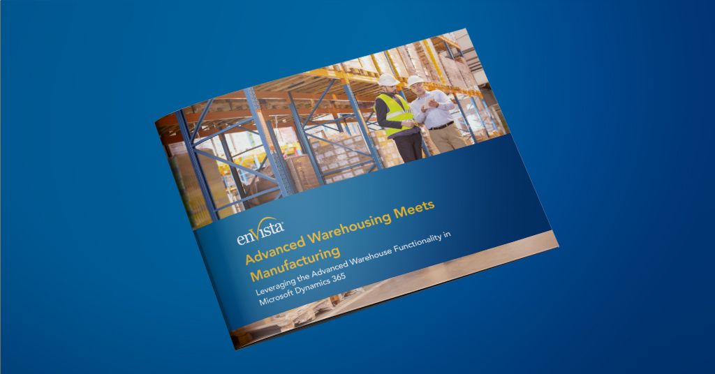 A brochure on a blue surface displays the enVista logo and the title Advanced Warehousing Meets Manufacturing with a photo of two construction workers in safety gear reviewing plans at a building site.