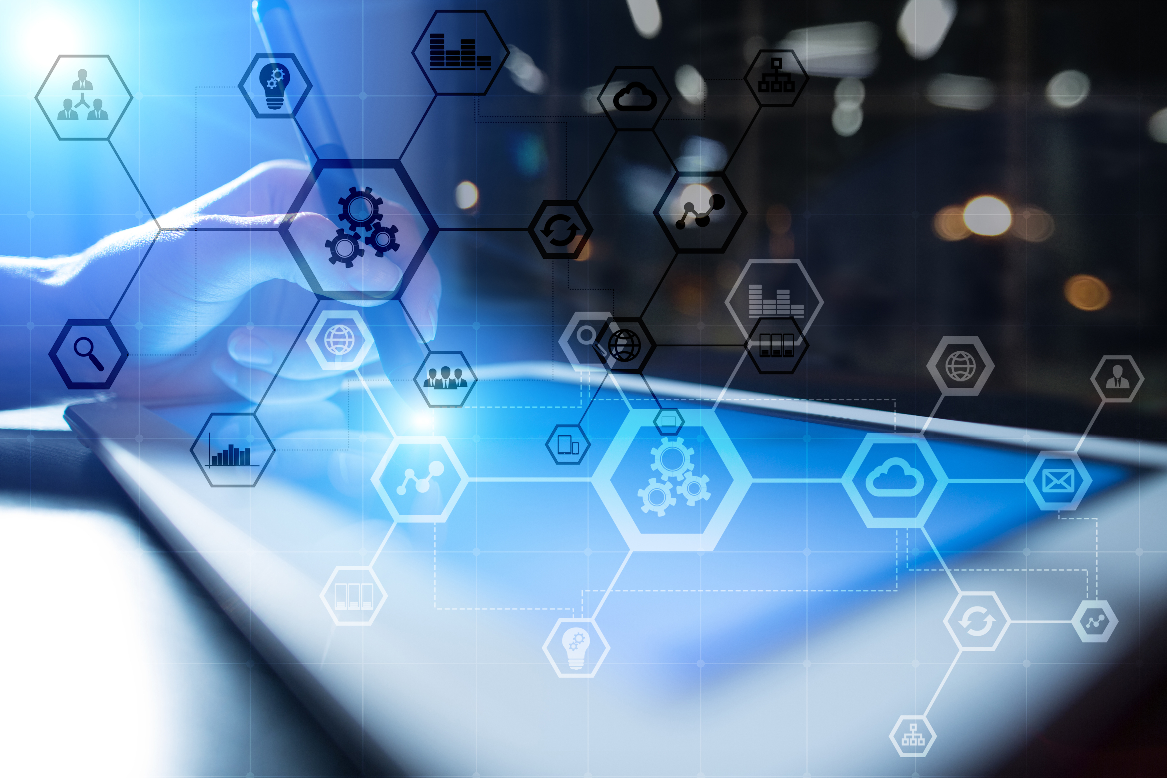 A person uses a stylus on a tablet with overlaid hexagonal icons representing technology, cloud computing, and data management, against a blurred background with blue and white lighting.