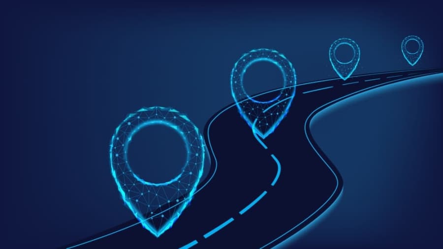 A digital illustration of a winding road with glowing blue location pins made of connected dots and lines, symbolizing navigation or mapping technology on a dark blue background.