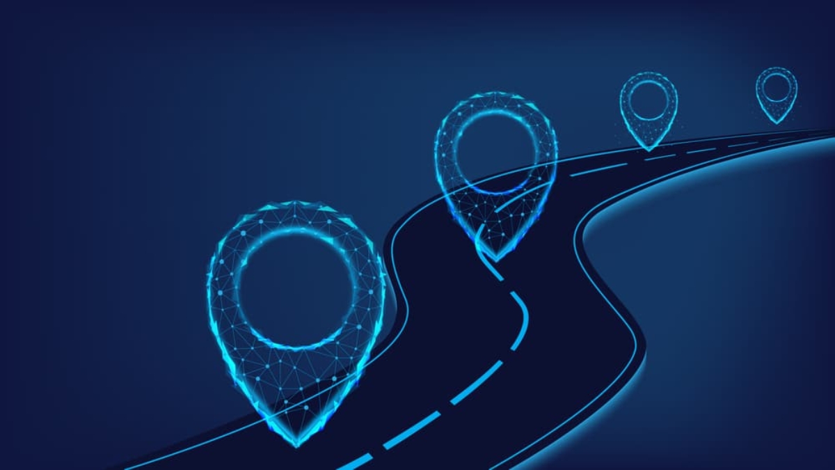 A digital illustration of a winding road with glowing blue location markers along the way, symbolizing navigation, journey, or progress against a dark background.