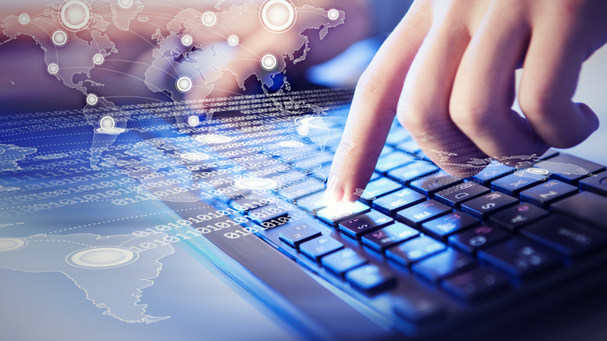 A close-up of fingers typing on a keyboard, with digital graphics of binary code and a world map overlay, symbolizing global communication and technology.