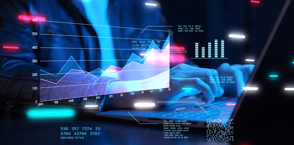 Person typing on a laptop with virtual graphs, charts, and data visualizations overlaid, symbolizing the dynamics of data analysis, business growth, or financial technology concepts. Neon colors and glowing effects highlight a modern, tech-focused scene.