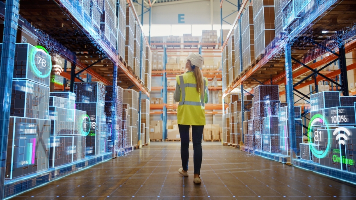 A person in a high-visibility vest and hard hat walks through a warehouse aisle lined with shelves, while digital data and graphs—powered by Microsoft Fabric—are overlaid, depicting smart technology and inventory management.
