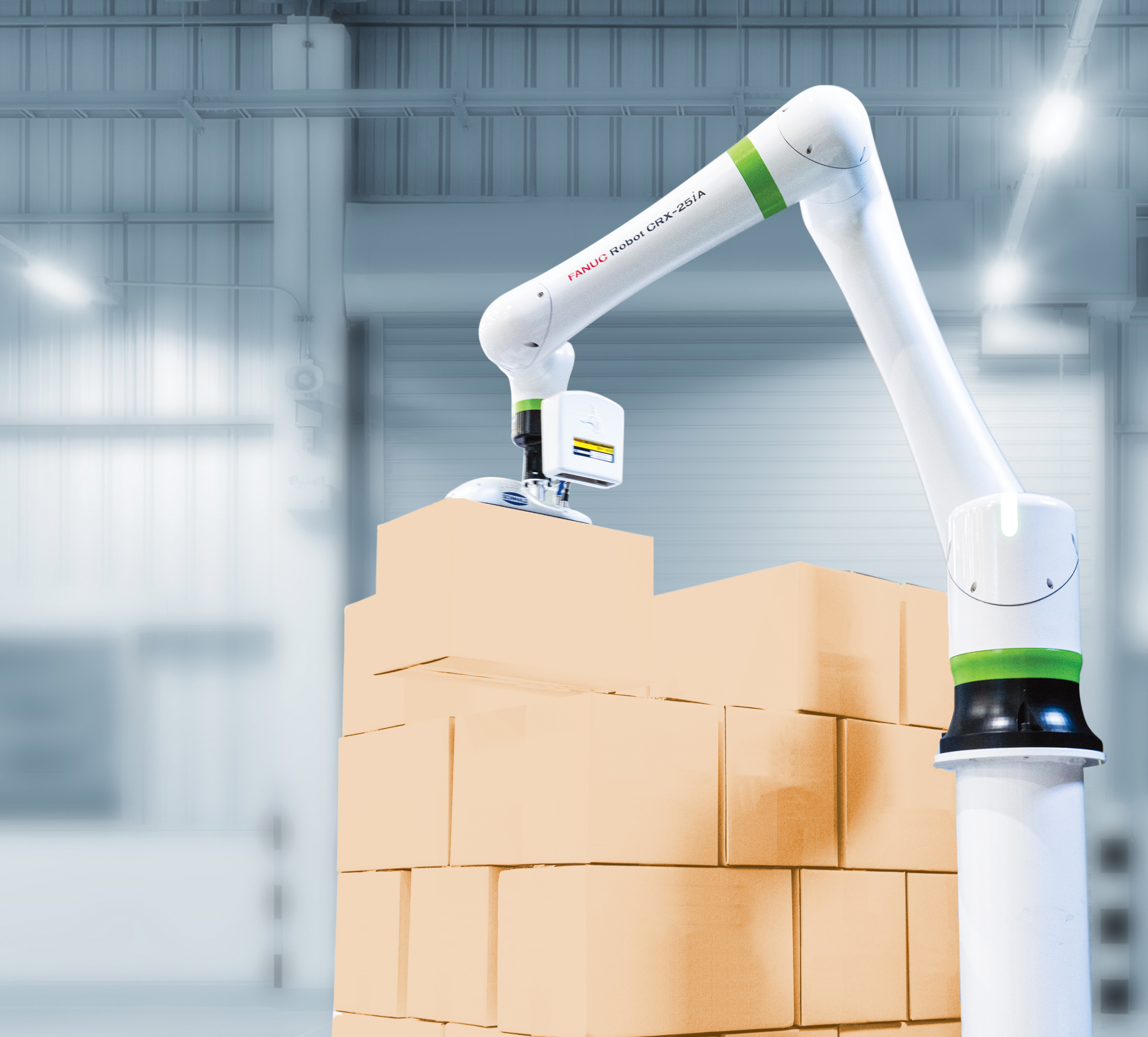 A robotic arm is stacking cardboard boxes in a warehouse with a bright, industrial interior. The background shows metal structures and large doors.