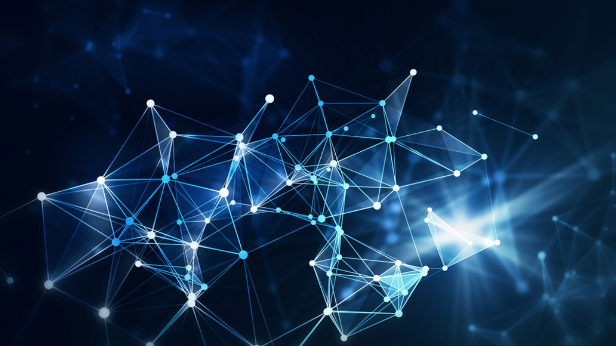 Abstract image of interconnected glowing blue and white lines and nodes forming a network or neural web, symbolizing the complexity of supply chain strategy, set against a dark blurred background with light flares.