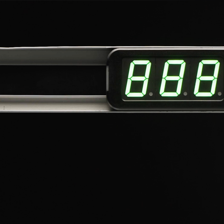 A close-up of a digital display showing the numbers 888 in green against a black background, with a circular button to the right and the enMotion logo below—a design offering a warehouse advantage in efficiency and control.